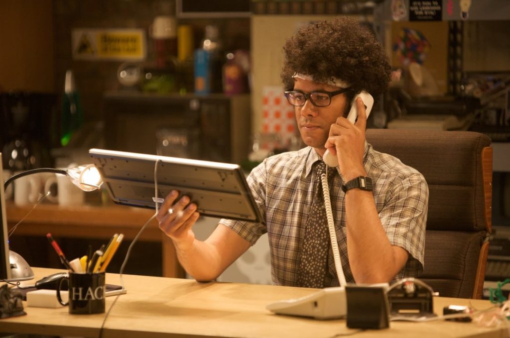 Man holding a computer keyboard like a telephone, from the IT Crowd – a humorous take on communication and technology.