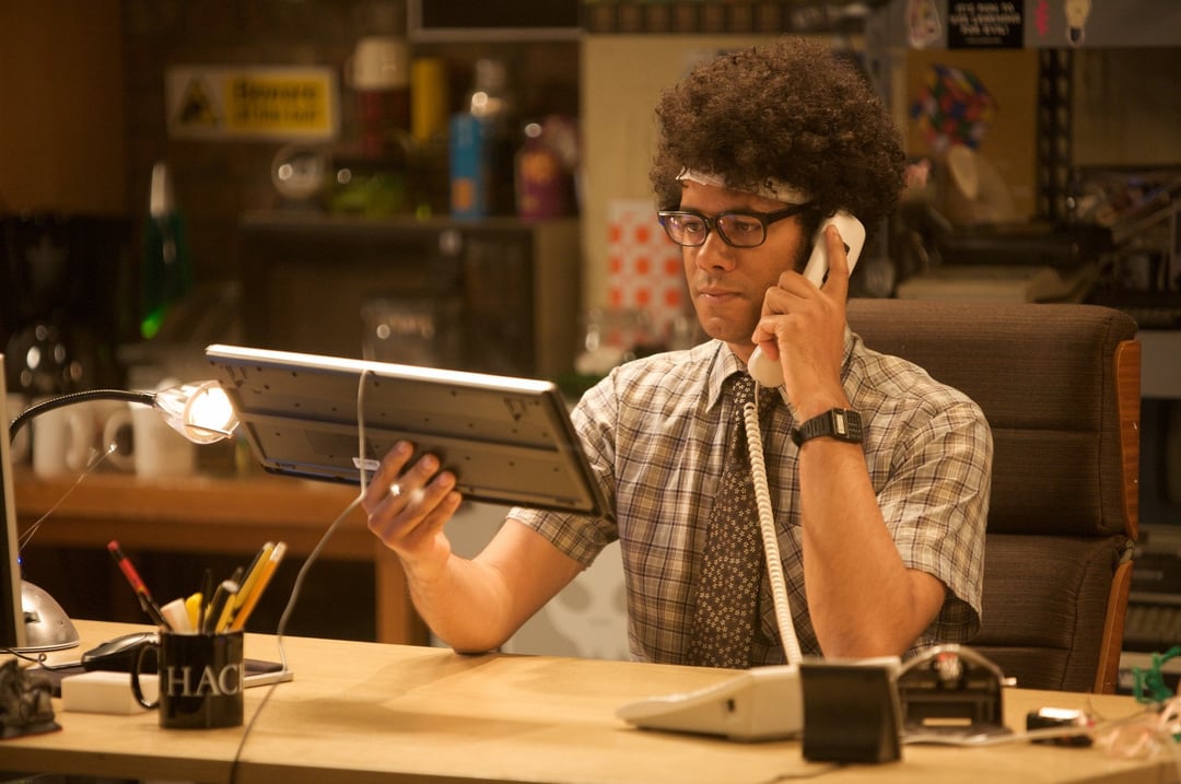 Man holding a computer keyboard like a telephone, from the IT Crowd – a humorous take on communication and technology.